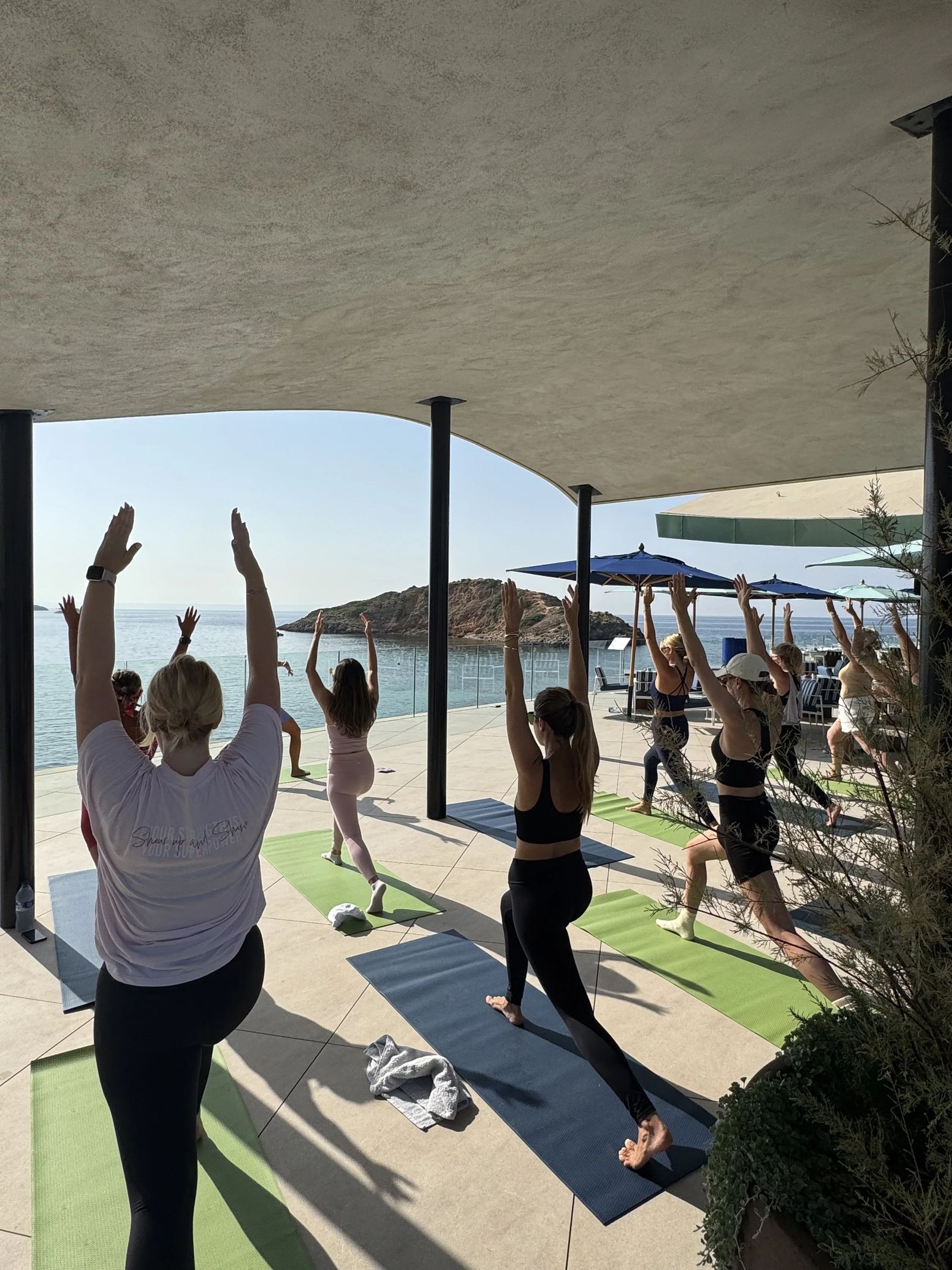 Participants en étirement sous la pergola lors d'une séance bien-être en beach club à Majorque