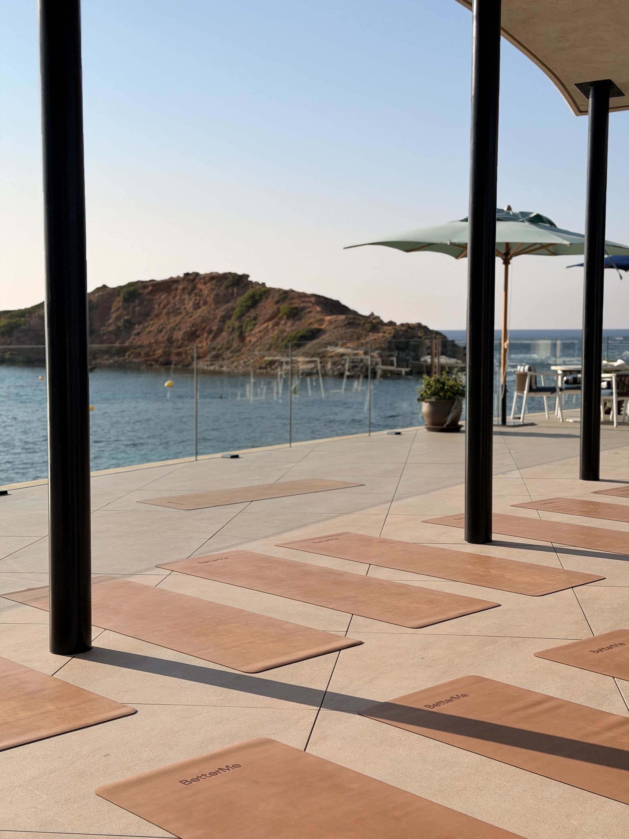 BetterMe mats laid out on a seafront terrace before a Pilates class in Mallorca