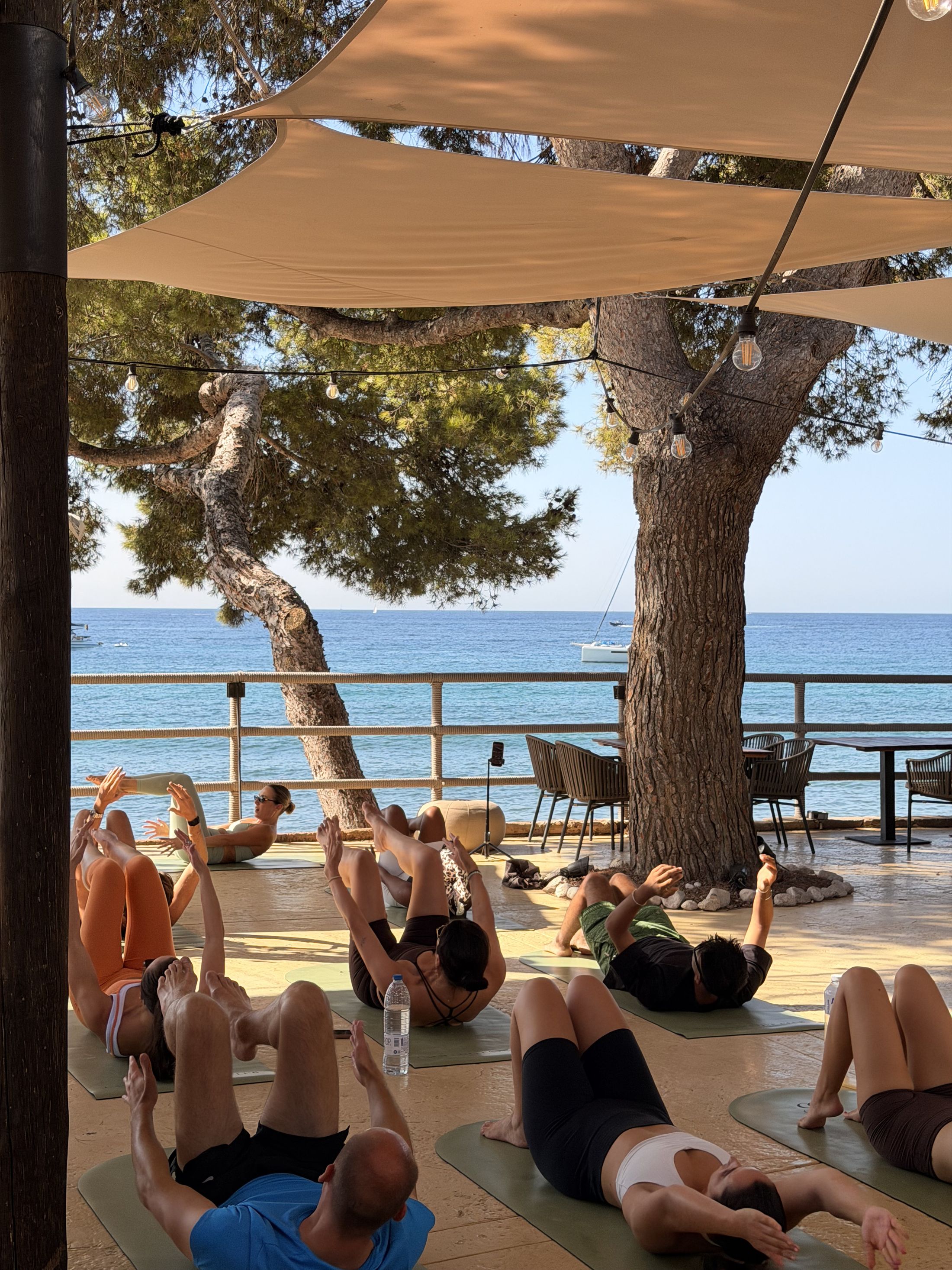 Pilates class under sail shades beside the Mediterranean in Puerto Portals